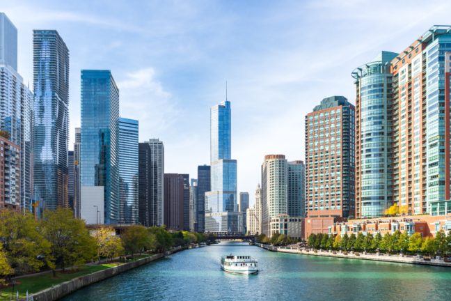 a boat traveling down a river next to tall buildings