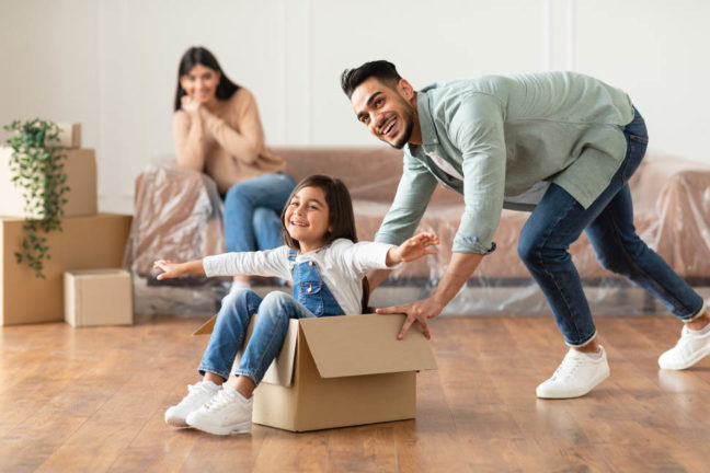 a man and a little girl playing in a cardboard box