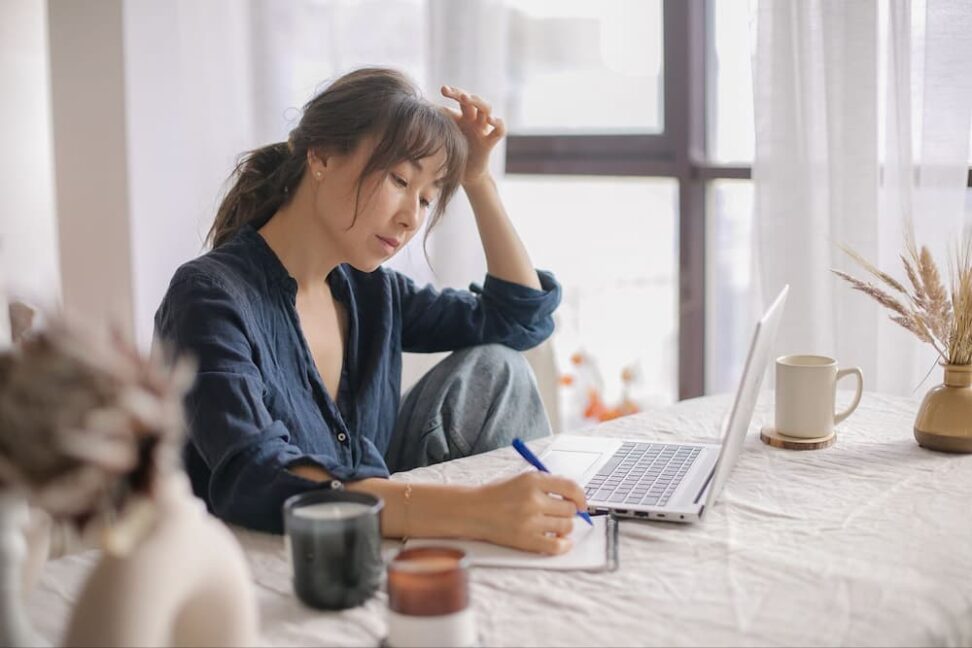 Asian woman at computer evaluating utah closing costs