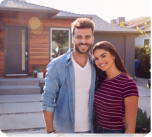 a man and a woman standing in front of a house